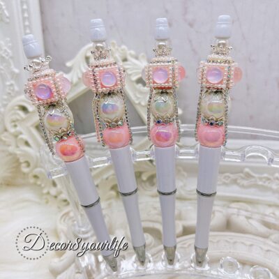 Elegant beaded ballpoint pen with embellished acrylic beads, rhinestone spacers, and silver-tone bead caps on a white base