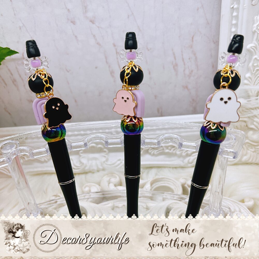 Halloween beaded pens with silicone and acrylic beads, rhinestone spacers, and an enamel ghost charm in black, pink, and white. Perfect for fall and gothic styles.