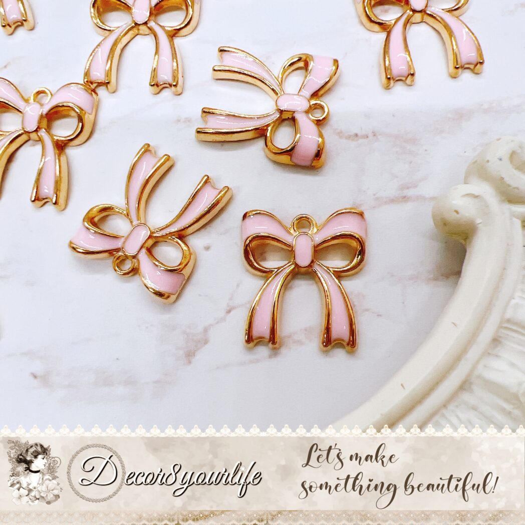 Set of 5 pink enamel bow charms for DIY crafts, jewelry making, and scrapbooks – gold-edged with high-quality pastel pink enamel.