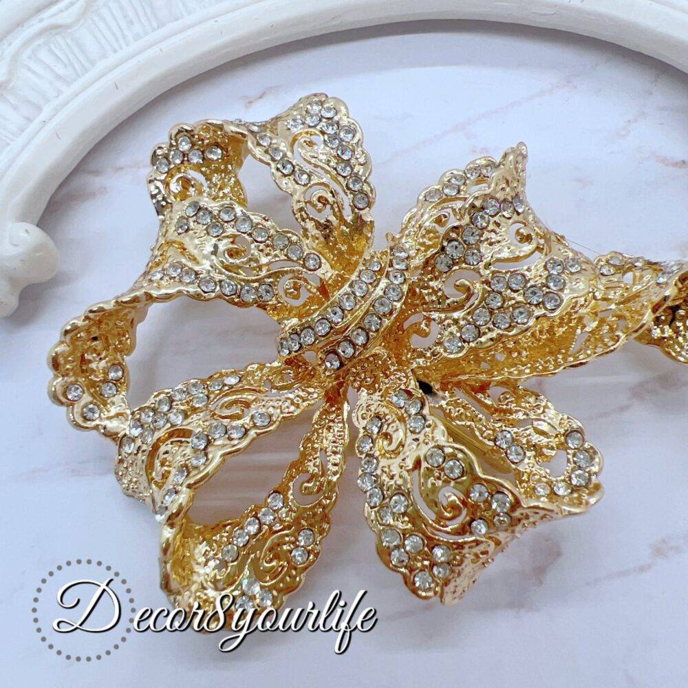 Large rhinestone bow brooch in gold-tone with intricate detailing, ideal for crafts and bridal decor.