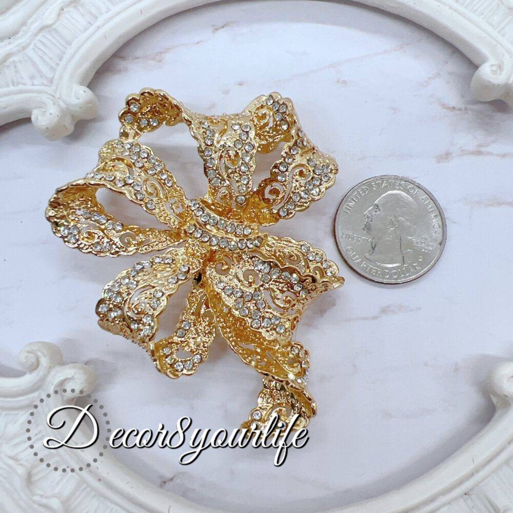 Large rhinestone bow brooch in gold-tone with intricate detailing, ideal for crafts and bridal decor.