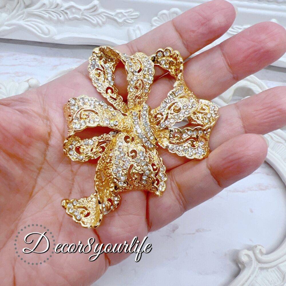 Large rhinestone bow brooch in gold-tone with intricate detailing, ideal for crafts and bridal decor.