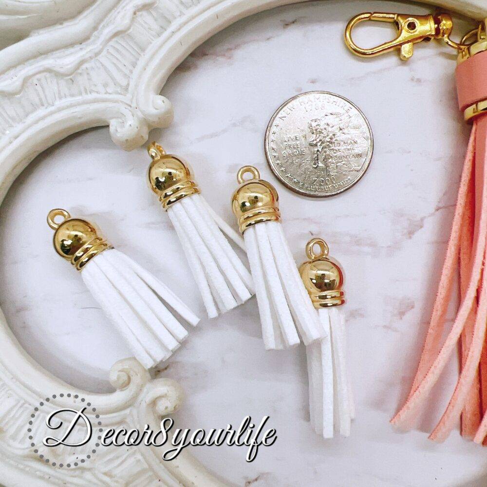 DIY tassel kit with four small white tassels (1.5 inches) and one large pastel peach tassel (3 inches) with a lobster clasp, ideal for crafting projects like scrapbooking, jewelry, and keychains.