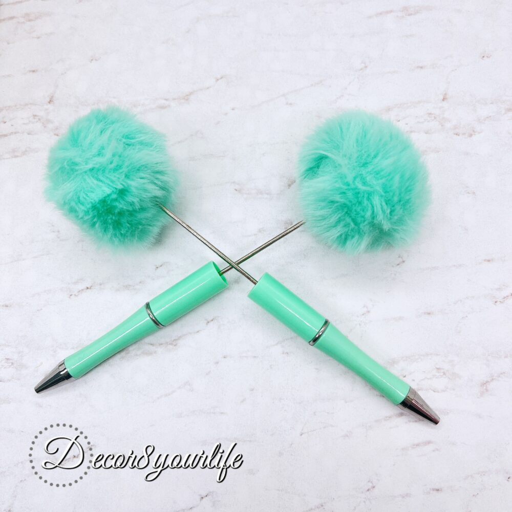 A set of two pastel pom-pom beadable pens featuring a soft, fluffy pom-pom topper and a sleek metal body.