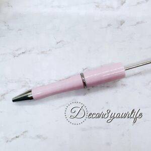 A set of two pastel pom-pom beadable pens featuring a soft, fluffy pom-pom topper and a sleek metal body.