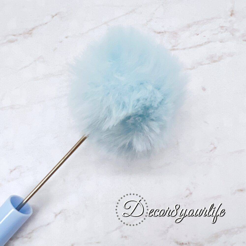 A set of two pastel pom-pom beadable pens featuring a soft, fluffy pom-pom topper and a sleek metal body,