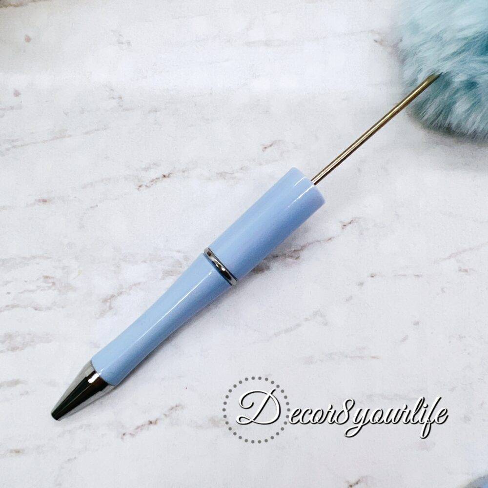 A set of two pastel pom-pom beadable pens featuring a soft, fluffy pom-pom topper and a sleek metal body,