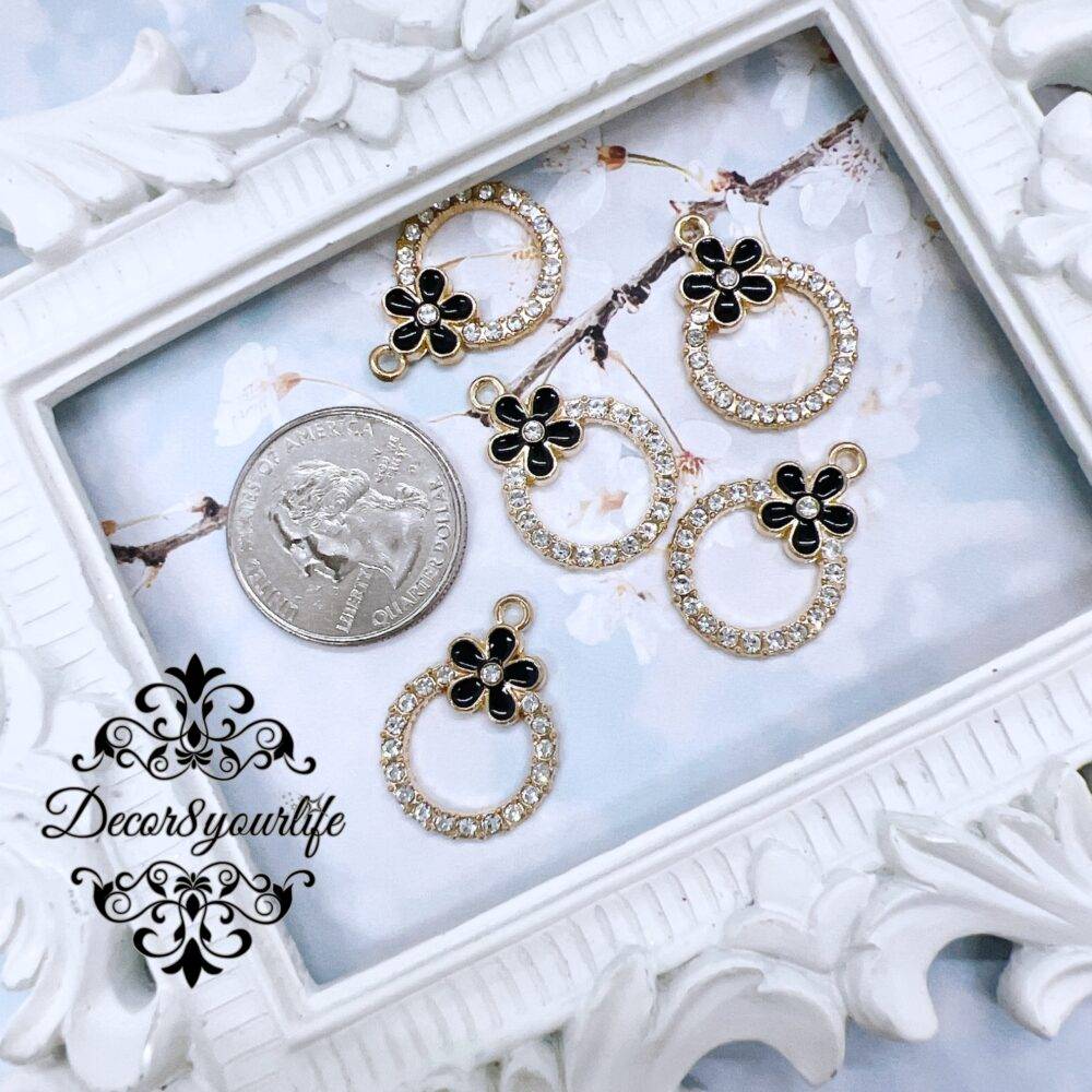 Set of five black enamel rhinestone charms displayed in a vintage white frame, perfect for DIY jewelry and craft projects.