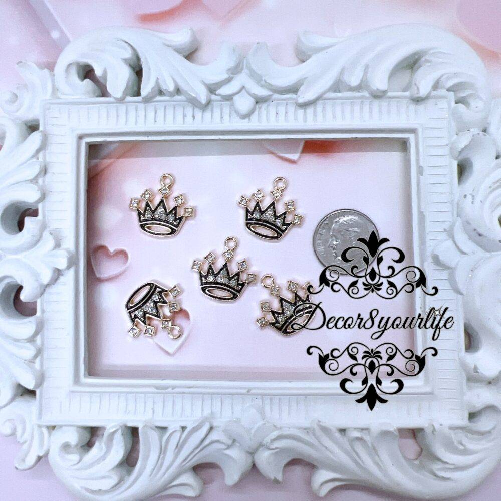 Set of five black enamel rhinestone crown charms displayed in a vintage white frame, perfect for DIY jewelry and craft projects.