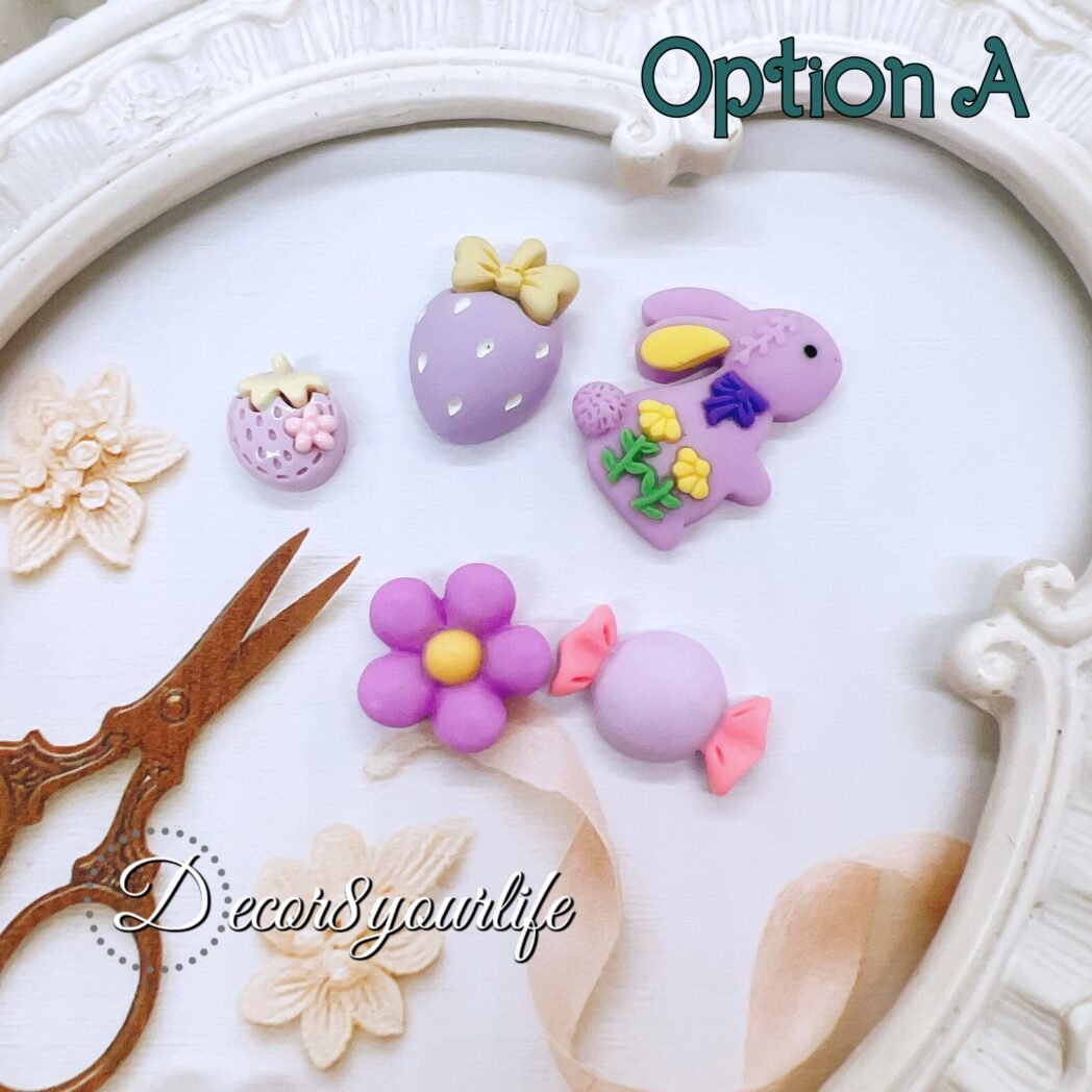Pastel purple flat-back cabochons in assorted shapes including bunny, flower, strawberry, and candy pieces. Displayed on a vintage frame with lace and craft scissors, ideal for DIY crafts, planners, and resin projects.