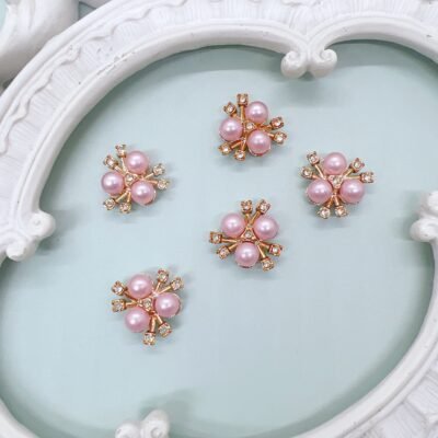 Pink pearl rhinestone cabochons with rose gold setting on a shabby chic background Flatback pink pearl cabochons for journals scrapbooks and DIY crafts Rose gold pearl rhinestone embellishments for shabby chic and vintage crafts