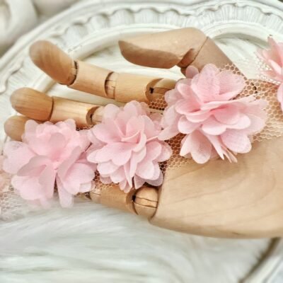 Pink chiffon flower embellishments on a strip with fourteen small flowers for baby headbands, cardmaking, and craft projects.
