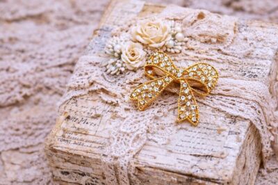 Gold rhinestone bow brooch used as a vintage journal embellishment on a shabby chic altered box