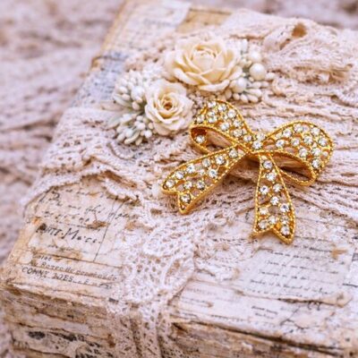 Gold rhinestone bow brooch used as a vintage journal embellishment on a shabby chic altered box