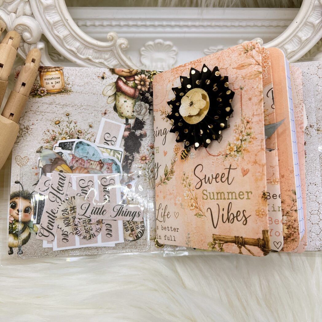 Transparent storage pocket inside the handmade micro traveler's notebook holding journaling cards, notes, stickers, and decorative ephemera.