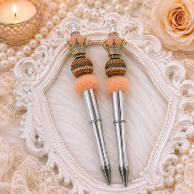 Handmade luxury faux fur crown pen featuring a polished silver-tone barrel, champagne and copper crystal pavé bead, apricot faux fur accent, blush designer bead, jeweled gold crown topper, and refillable black ink.