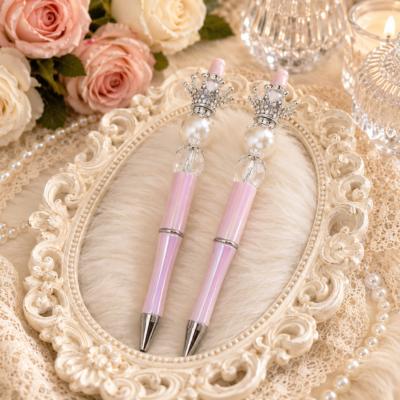 Luxury handmade blush pink iridescent refillable beaded pen featuring a silver crystal crown topper, luminous pearl centerpiece, faceted crystal bead, decorative silver bead caps, and polished silver hardware by Decor8yourlife.