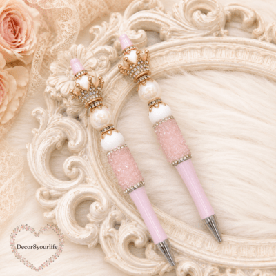 Handmade pink beaded gift pens with silver jeweled crowns, iridescent pearl beads, and blush pink barrels by Decor8yourlife displayed on an elegant vintage styled background.