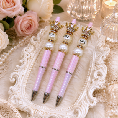 Luxury handmade blush pink iridescent refillable beaded pen with jeweled gold crown topper, LOVE pearl accent, pearl beads, rhinestone spacers, and silver hardware by Decor8yourlife.